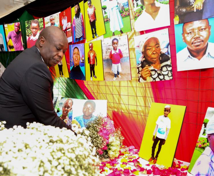 Laying flowers on the table of portraits of the Maai Mahiu flood victims 